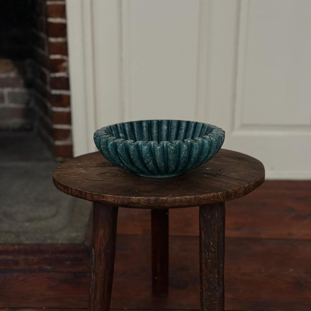 Ruffle Bowl in Emerald marble on a dark wood stool