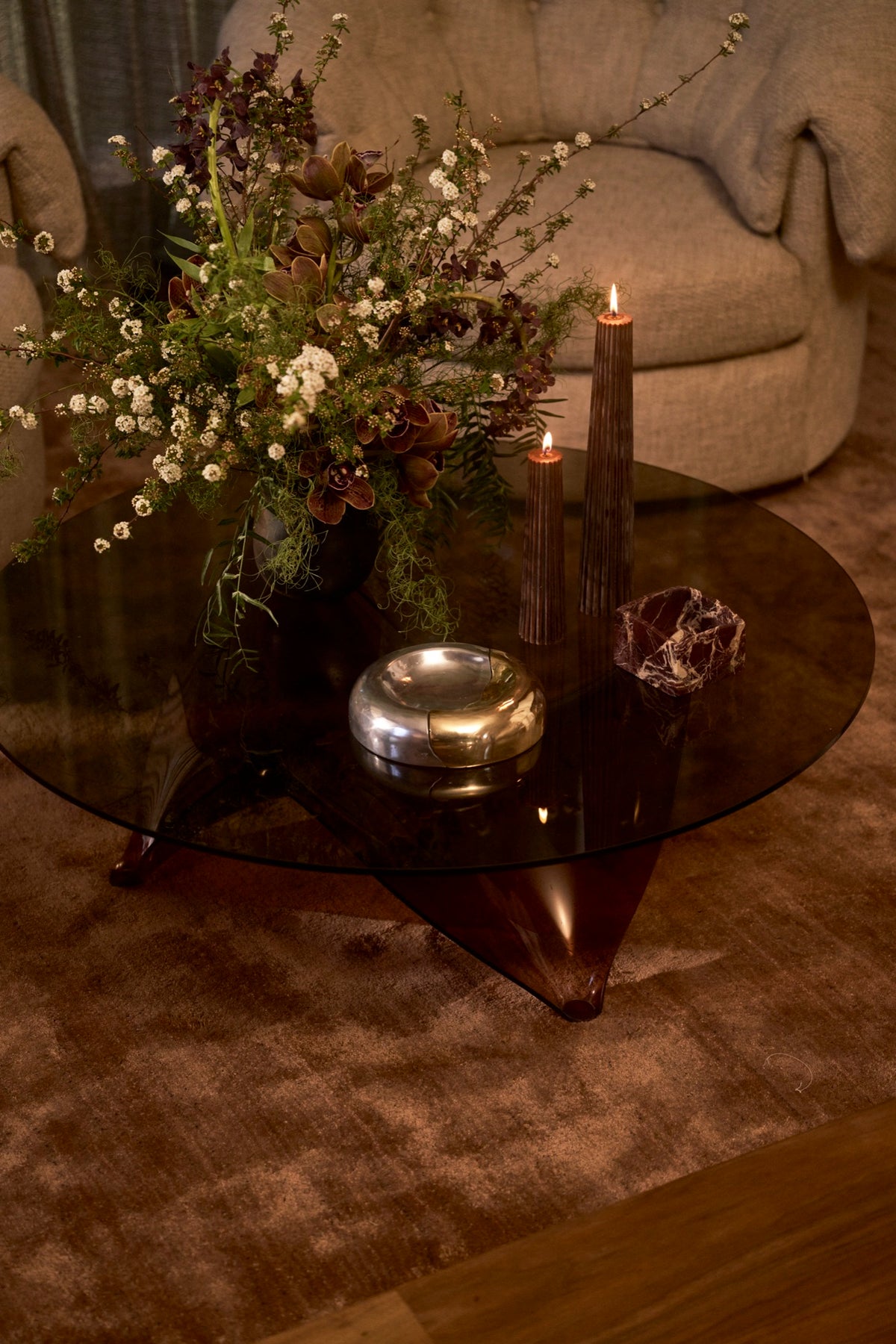 The Fusion Bowl on a glass table beside wildflowers and candles