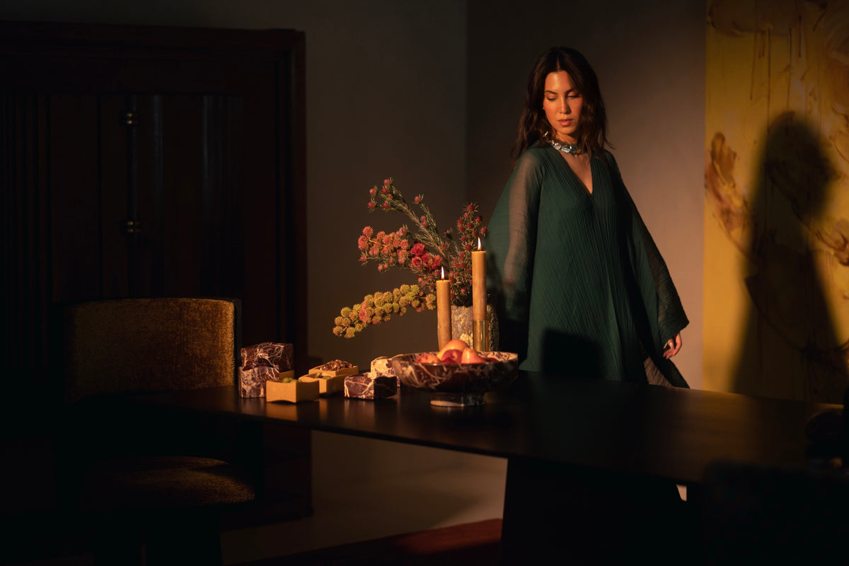 Tania Sarin in green standing beside a candlelit dinner table