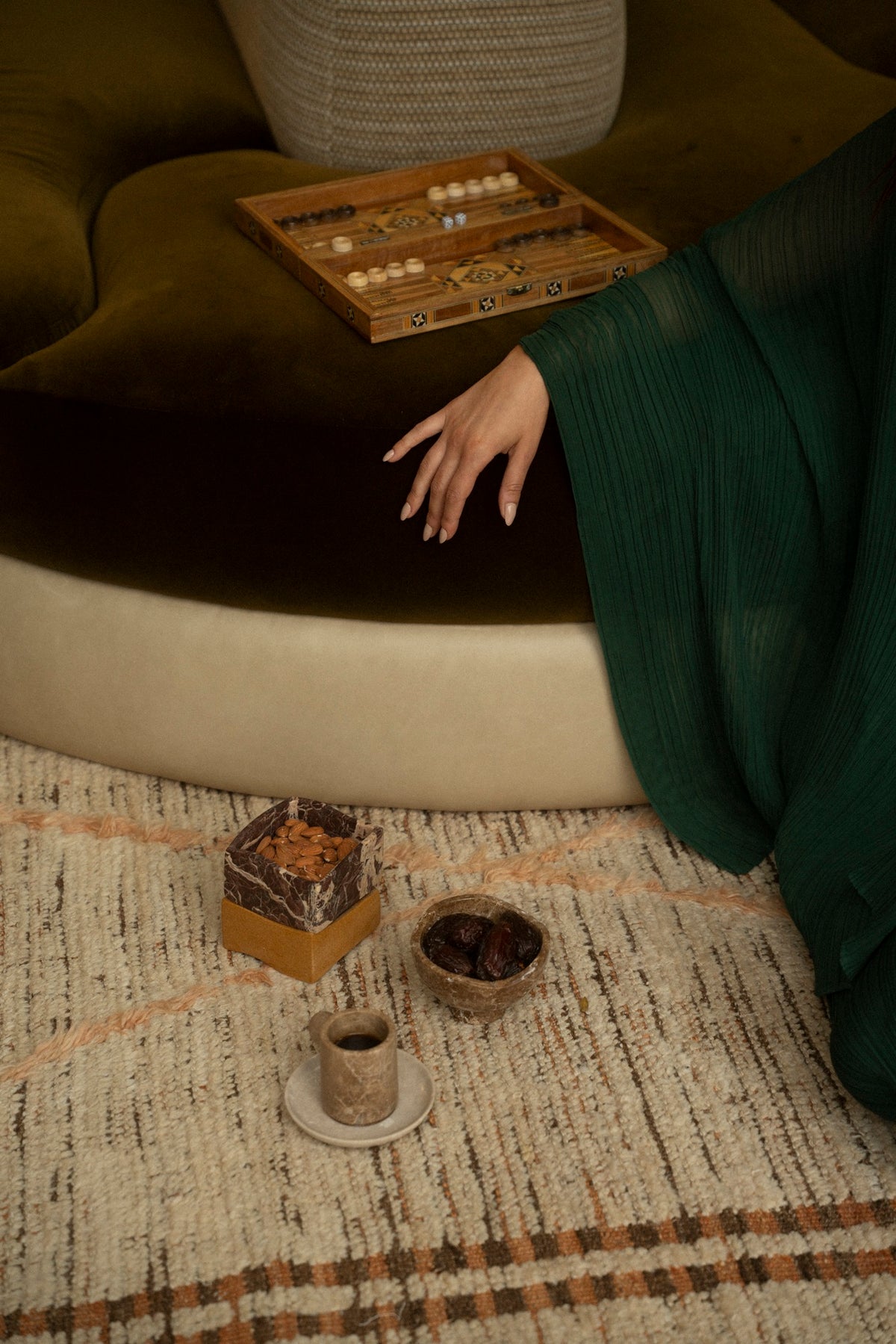 A hand reaching toward a marble box on a low stone bench