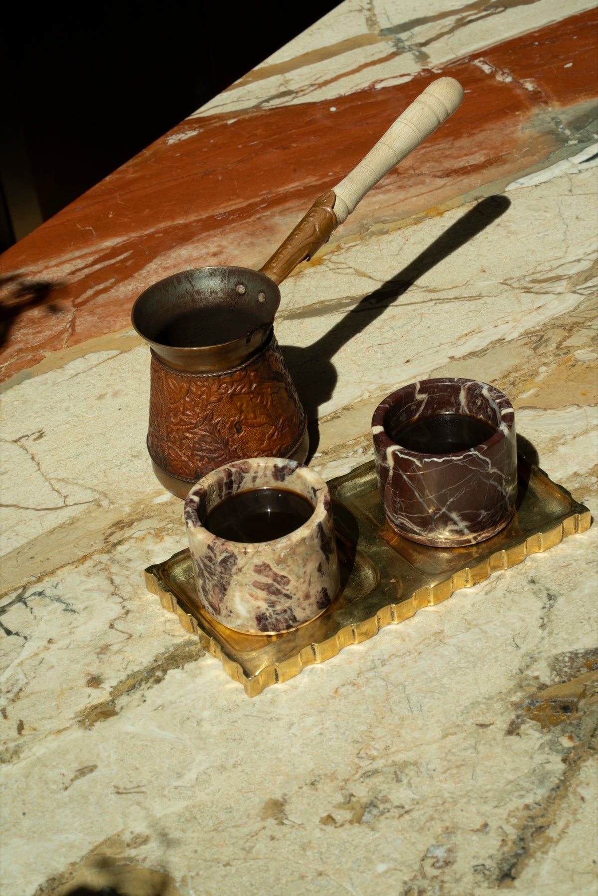 Cherry Gold cups and a copper pot on the marble bar in afternoon sun