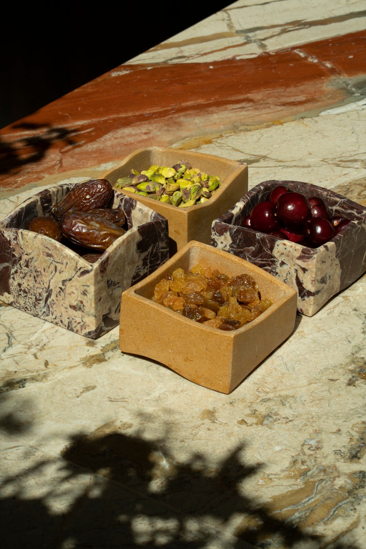 Marble and stone mezze boxes of dates, pistachios, cherries and golden raisins on Tania's marble bar