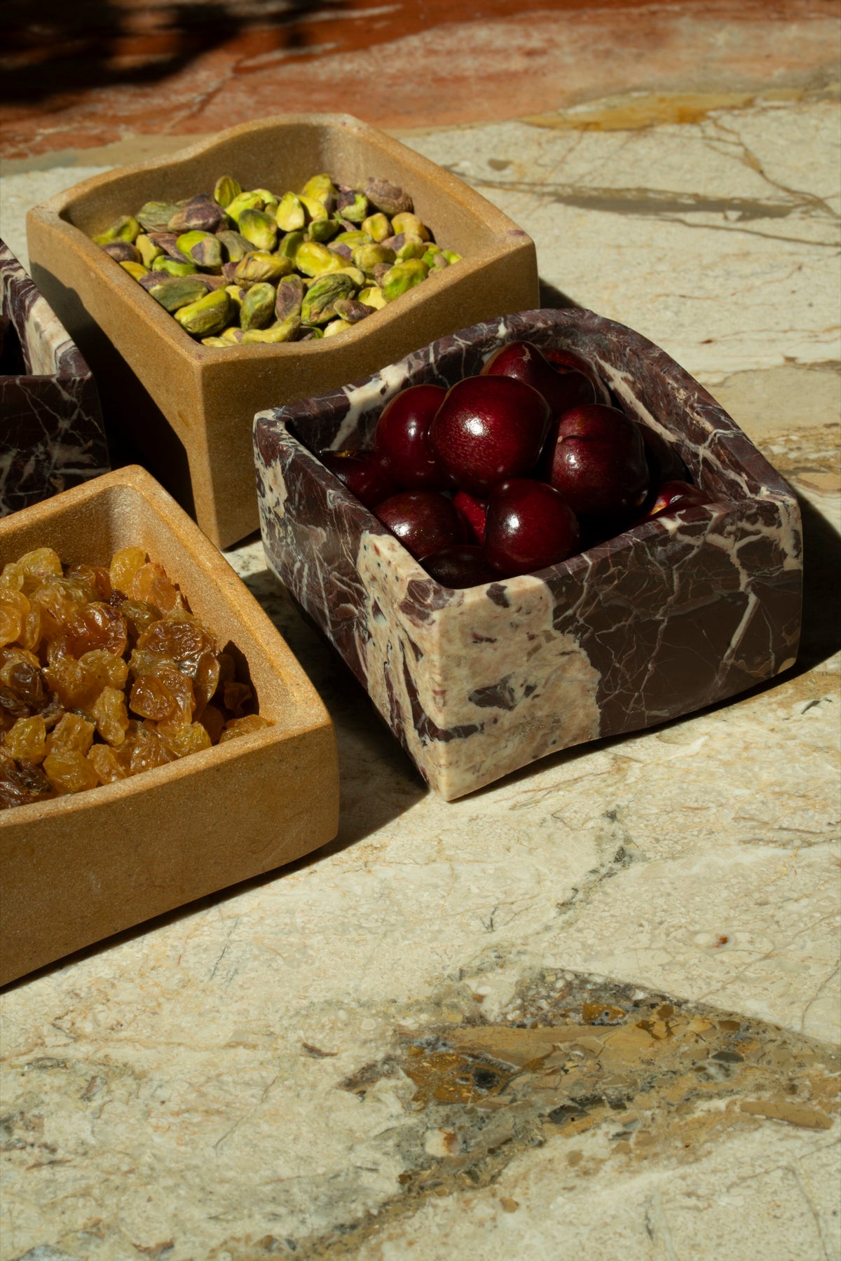 Mezze boxes of pistachios, cherries and golden raisins in afternoon sun