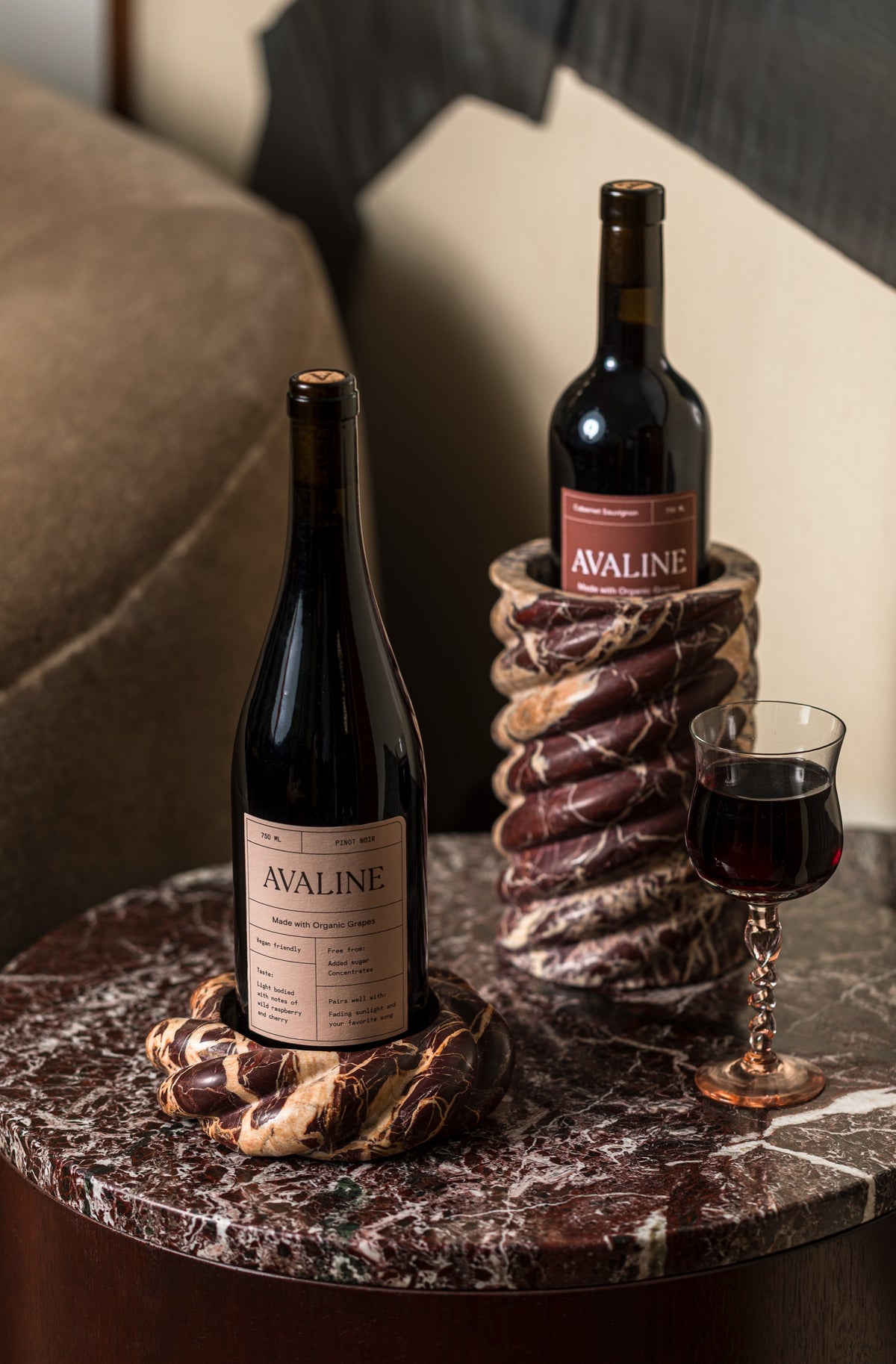 Wine Chiller and Wine Coaster in Cabernet Red Marble holding bottles of Avaline red wine