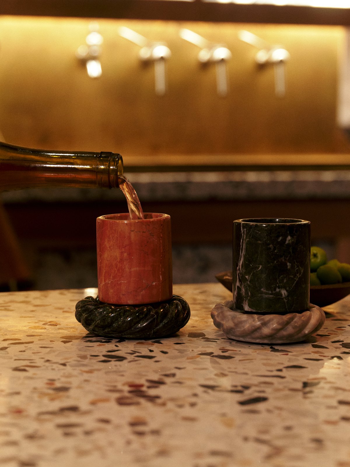 Wine poured into a marble cup on a twisted stone coaster at a terrazzo bar